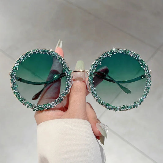 Apportez une touche de glamour rétro avec les lunettes GM LUMIAS : monture ronde oversize, strass étincelants et verres dégradés pour un look à la fois chic et audacieux.